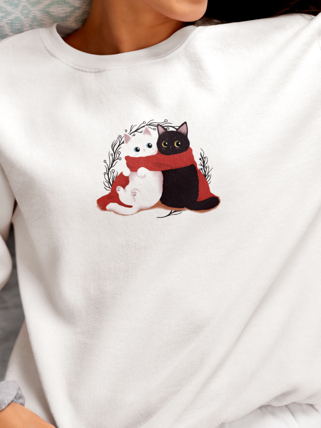 Person wearing a white sweatshirt with cartoon cats design