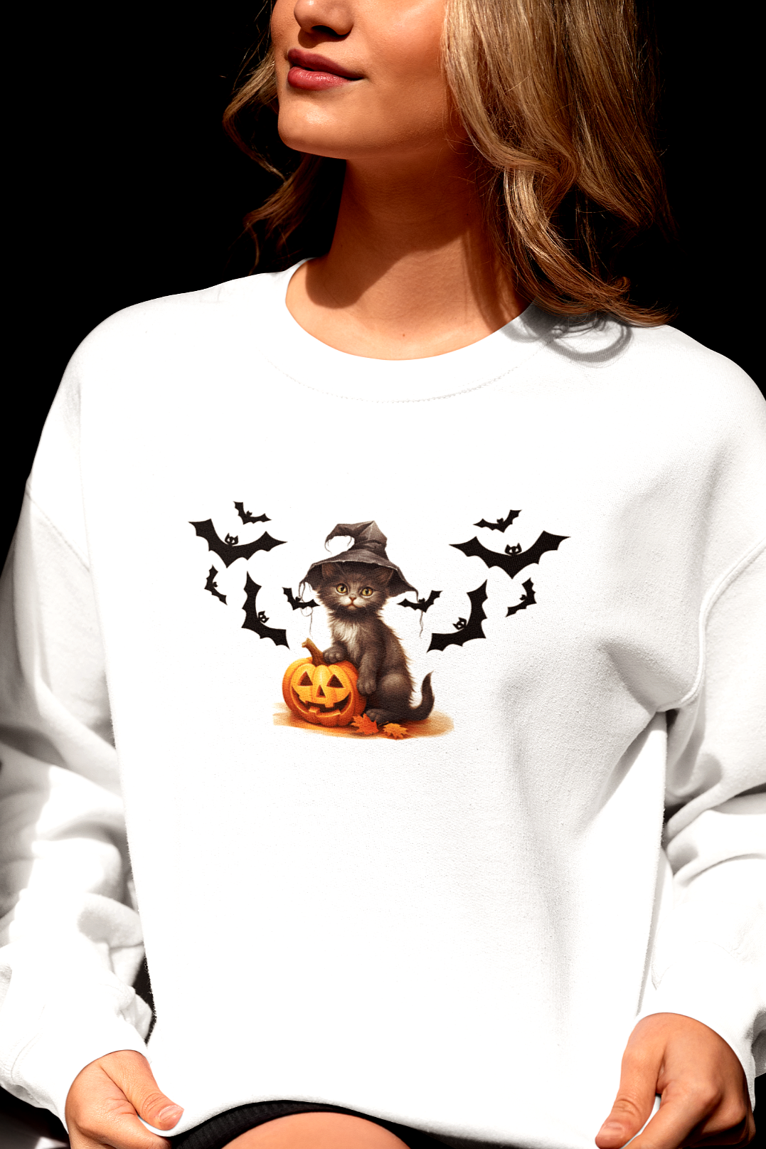 Person wearing a white sweatshirt with a Halloween design featuring a dog, pumpkins, and bats.