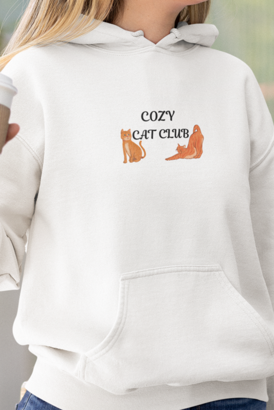 Woman wearing a white hoodie with 'Cat Club' text and graphics, holding a coffee cup outdoors.