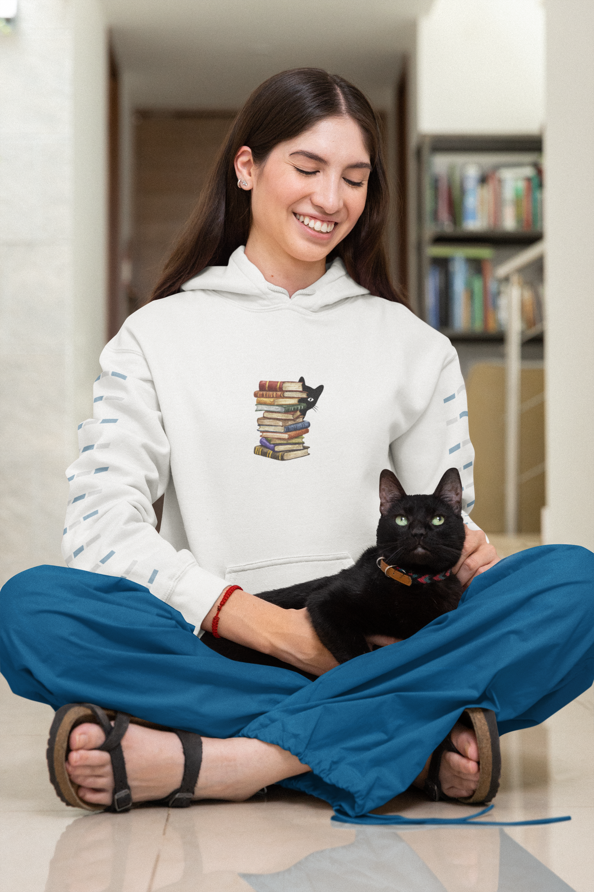 Stack of books with black cat looking round books hoodie