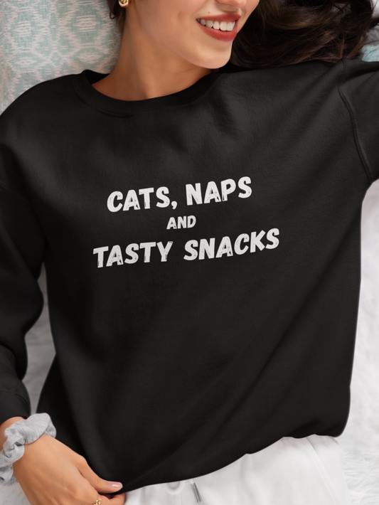 Person wearing a black sweatshirt with 'CATS, NAPS AND TASTY SNACKS' text.