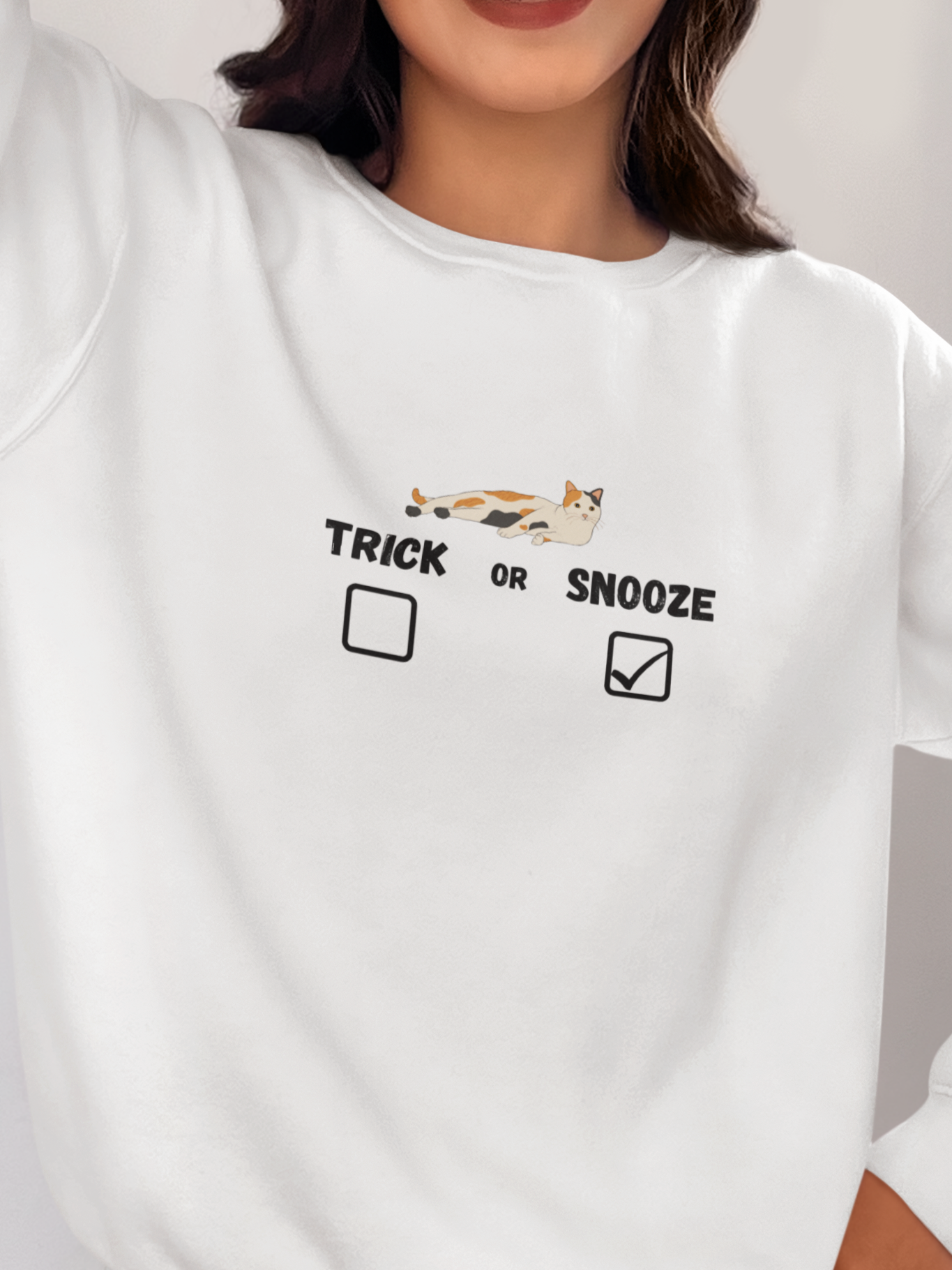 Person wearing a white sweatshirt with text and graphics, standing indoors.