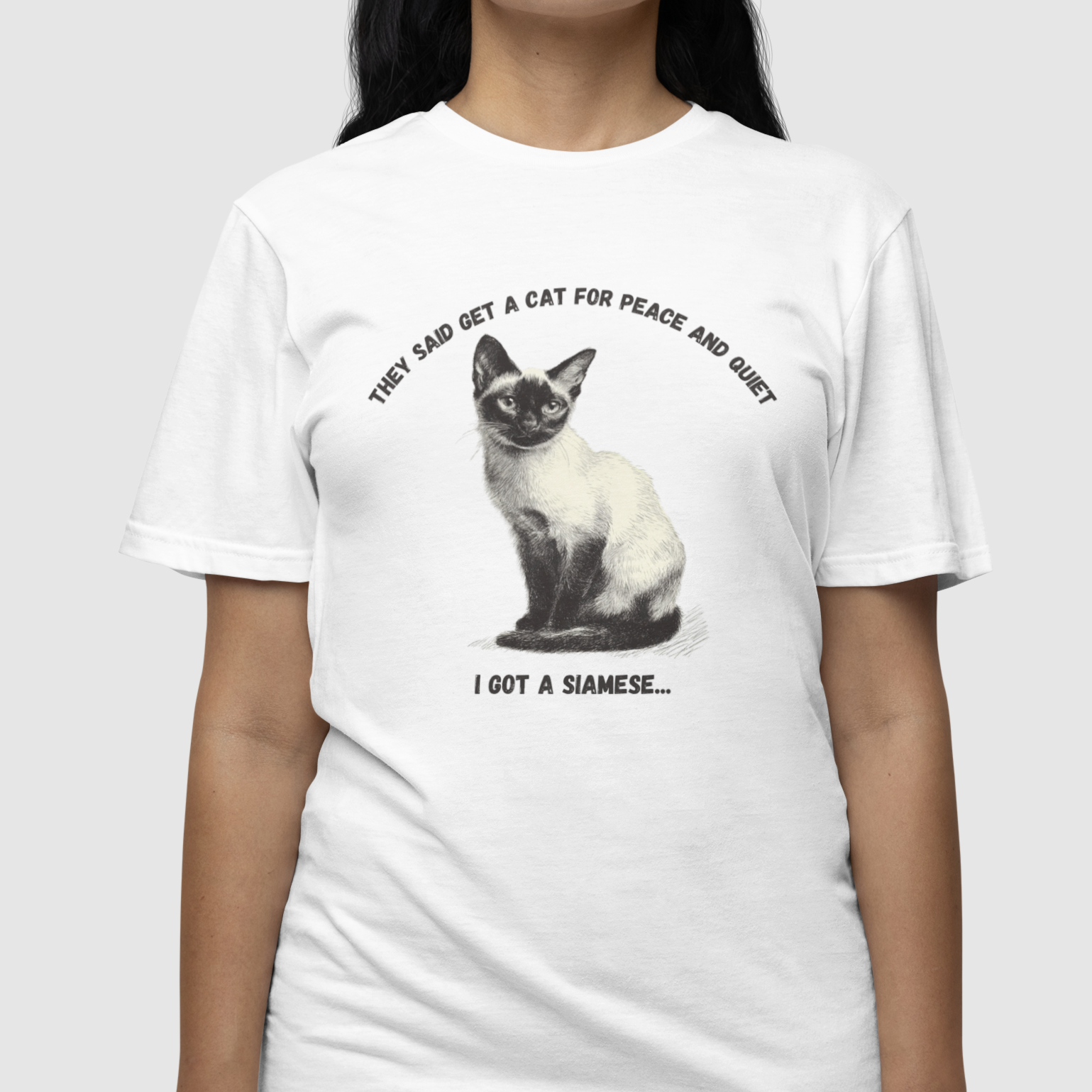 Person wearing a white t-shirt with a Siamese cat graphic and text.