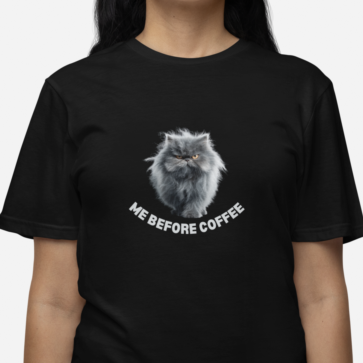 Black t-shirt with a cat graphic and text 'Me Before Coffee' worn by a person on a white background