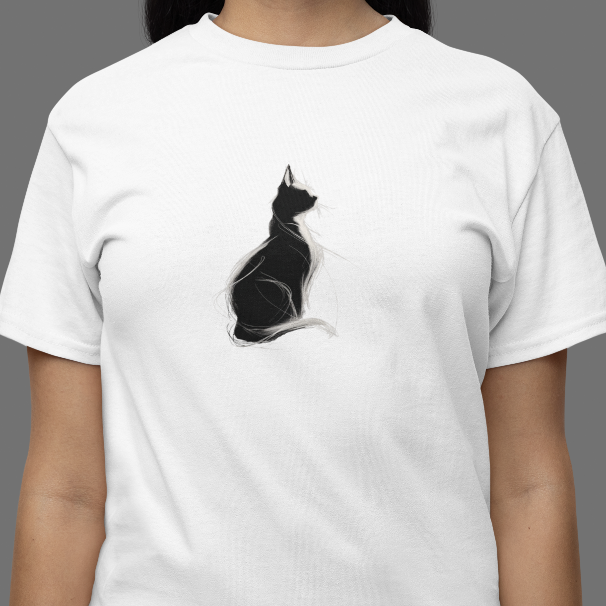 White t-shirt with a black cat graphic worn by a person on a gray background