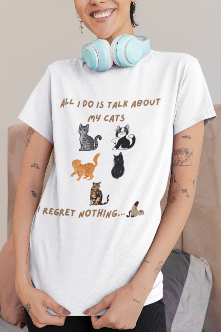 Woman wearing a white t-shirt with cat illustrations and text in a bedroom setting.