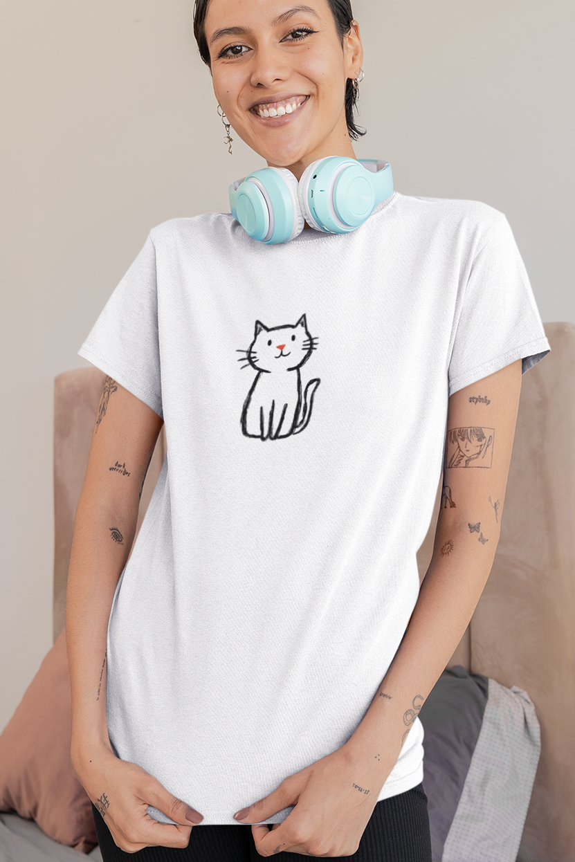 Woman wearing a white t-shirt with a cat graphic in a bedroom setting