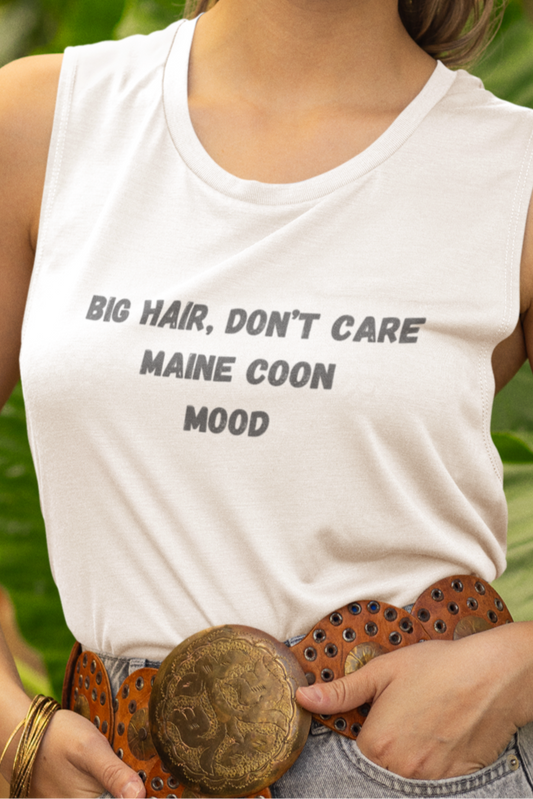 Woman wearing a white sleeveless shirt with text, denim shorts, and a brown hat in a garden setting.