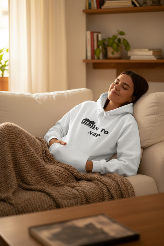 Person relaxing on sofa in Born To Nap hoodie