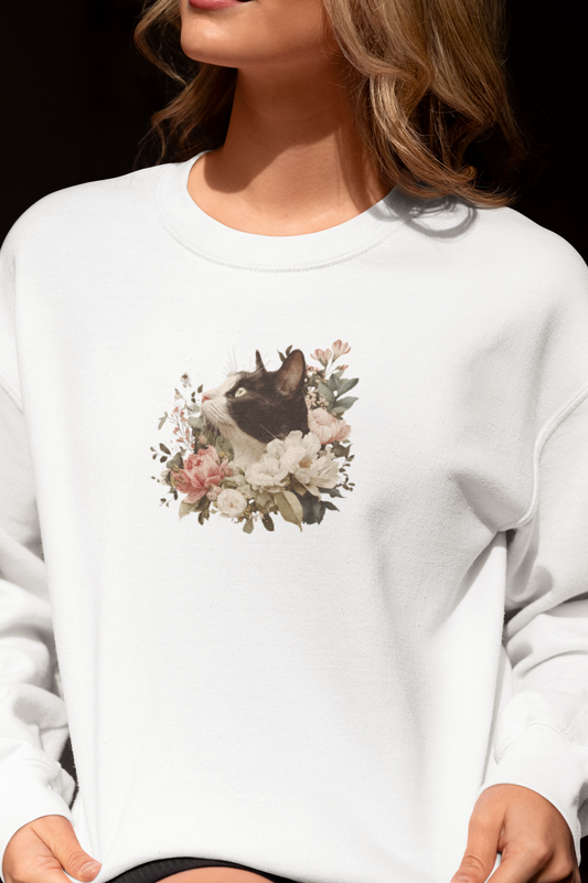 Person wearing a white sweatshirt with a floral and cat design.