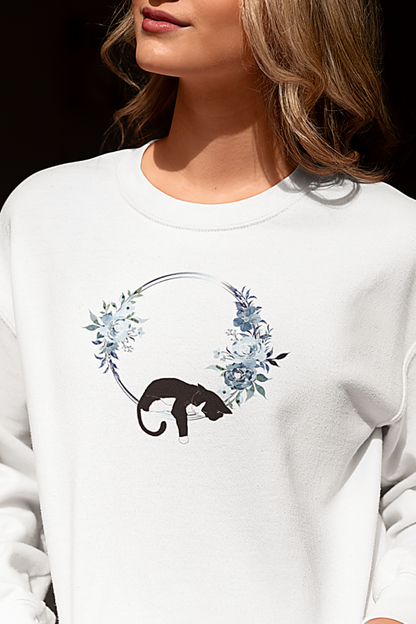 Person wearing a white sweatshirt with a panther design sitting on a white surface.