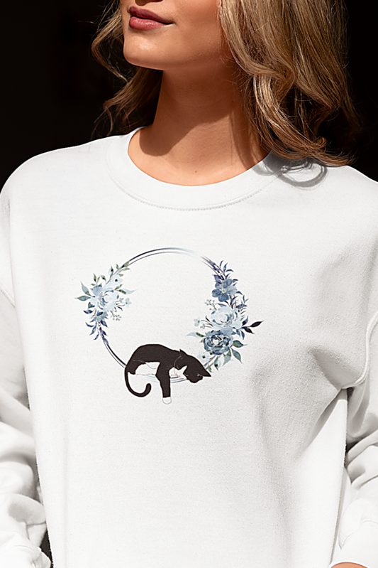 Person wearing a white sweatshirt with a panther design sitting on a white surface.